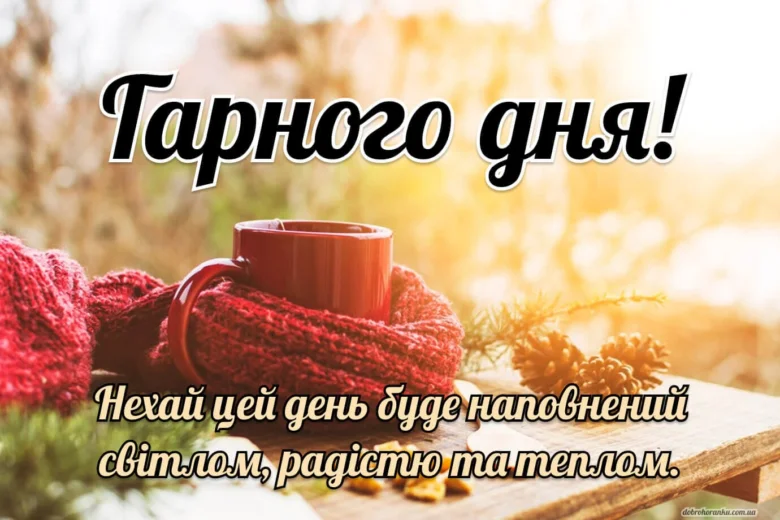 Чашка кави в червоній шали на дерев'яній дошці.