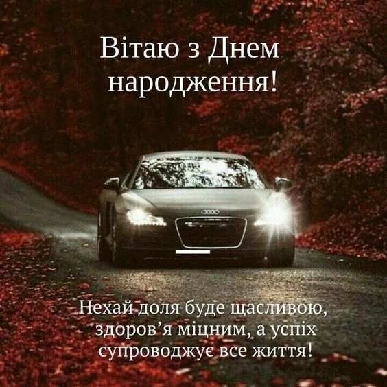 Чорний автомобіль на дорозі серед червоних листя з привітанням.