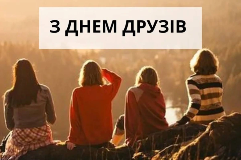 Чотири друзі сидять на пагорбі, вітаючи з Днем дружби.