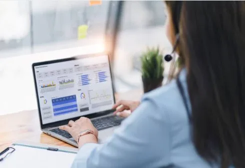 Woman working on laptop with analytics dashboard