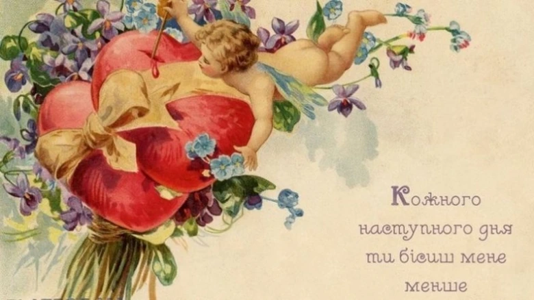 Купід серед серць та квітів з привітанням на День закоханих.