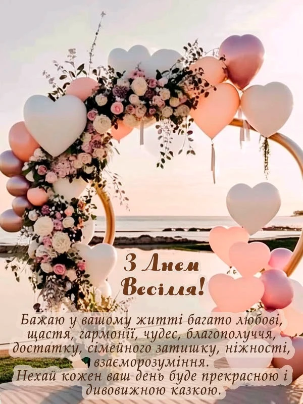 Весільна арка з квітами та серцевими кульками на заході сонця